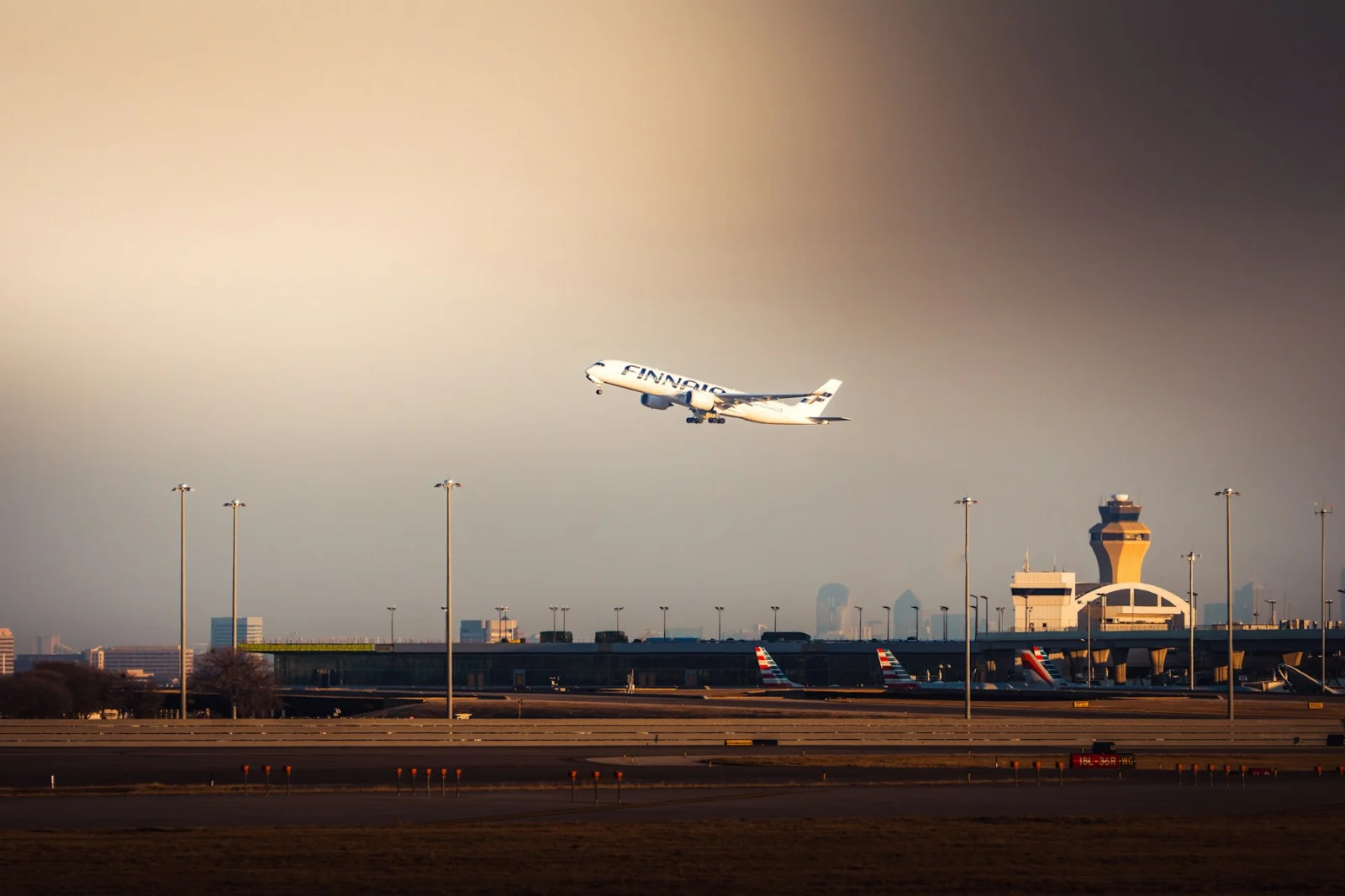 Passenger aircraft taking off beside the control tower at DFW International Airport